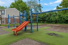 Springfield apartment for rent - A playground with a red slide and a blue monkey bar.