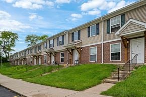 Springfield apartment for rent - A row of townhouses with green lawns and trees in the background.