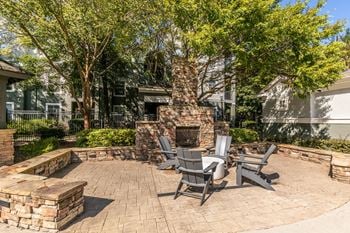 A patio with a table and chairs and a brick fireplace