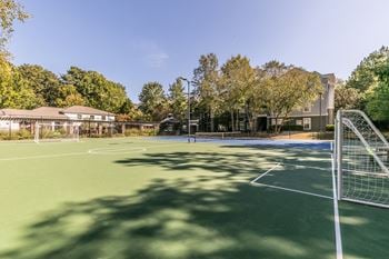 A tennis court with a net and a building in the background