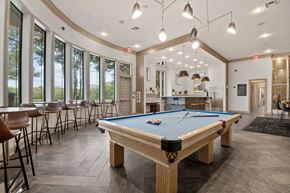 Plano apartment for rent - a pool table in the clubhouse of a community with tables and chairs at Mission Gate, Plano