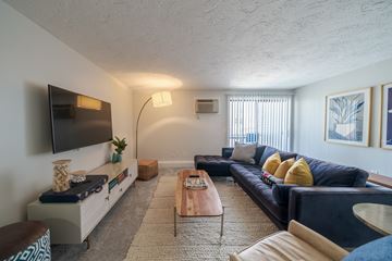 Randolph apartment for rent - A living room with a black couch and a wooden coffee table.