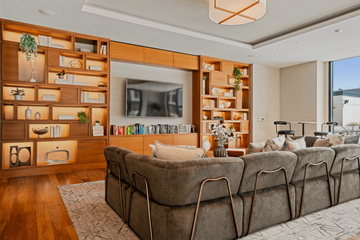 Minneapolis apartment for rent - A living room with a large couch and a television on a wooden wall.