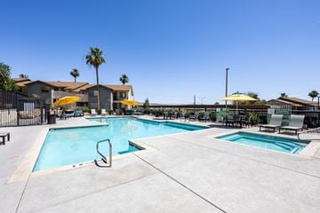 Henderson apartment for rent - A swimming pool with a yellow umbrella and a palm tree in the background.