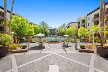 Woodland Hills apartment for rent - A courtyard with a fountain surrounded by palm trees and apartment buildings.