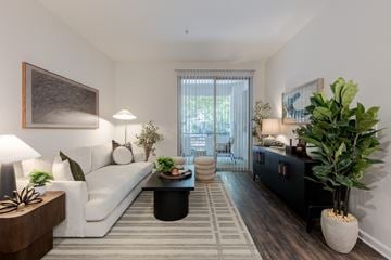 Woodland Hills apartment for rent - A living room with a white sofa, a black coffee table, and a large painting on the wall.