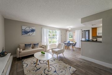Pembroke Pines apartment for rent - A living room with a white couch, a white coffee table, and a blue and white rug.