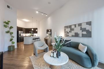 Woodland Hills apartment for rent - A modern living room with a grey couch, a white coffee table, and a large abstract painting on the wall.
