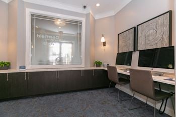 A conference room with two desks and two monitors