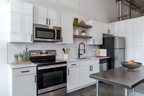 Charlotte apartment for rent - a modern kitchen with a stainless steel oven and microwave at Highland Mill Lofts in Charlotte, 28205