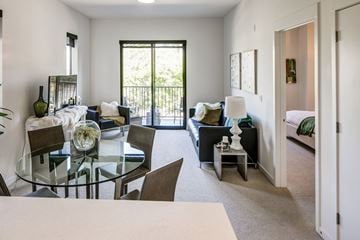 San Jose apartment for rent - A modern living room with a glass table and chairs.