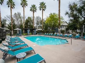 Las Vegas apartment for rent - a resort style pool with blue lounge chairs and palm trees
