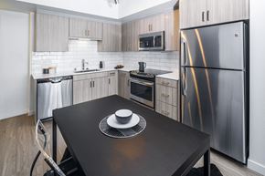 Los Angeles apartment for rent - a kitchen with stainless steel appliances and a black table at OLiVE DTLA in Los Angeles, California