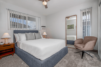 Cozy bedroom with a large bed, plush carpeting, and an accent chair