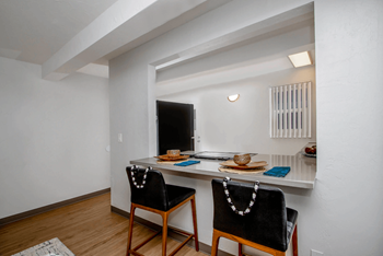 View of the breakfast bar facing the kitchen with a counter top and two chairs