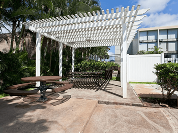 A patio with a picnic table and a pergola