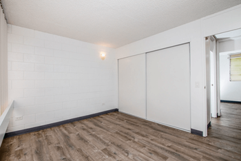 A living room with white walls and plank flooring