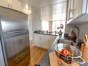 A kitchen with a stainless steel refrigerator and a sink