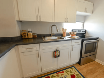 A white kitchen with marble counter tops and white cabinets