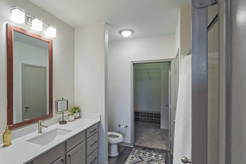 Oversized walk-in closet with plush grey carpeting and built-in organization with framed mirror 