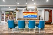 Dallas apartment for rent - a dining room with blue chairs and a table with a colorful painting at South Side Flats, Dallas, Texas