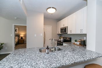 A kitchen with a granite counter top and a sink