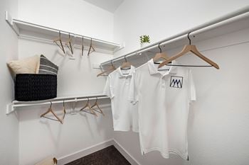 White shirts hanging on a rack in a dressing room