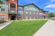 Littleton apartment for rent - a sidewalk in front of an apartment building with a lawn at Switchback on Platte Apartments, Littleton, CO