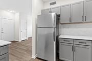 Littleton apartment for rent - a renovated kitchen with stainless steel refrigerator and white cabinets at Switchback on Platte Apartments, Littleton, Colorado