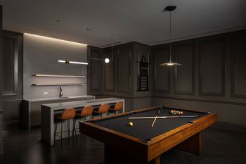 A dark room with a pool table and a bar