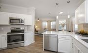 Pearland apartment for rent - a kitchen with white cabinets and stainless steel appliances at Sladestone Shadow Creek, Pearland