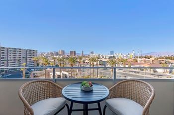 Balcony with two chairs and a table overlooking the city