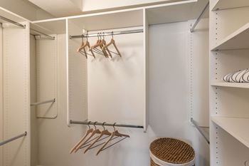 Walk in closet with hooks and a white wall