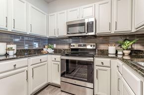 Houston apartment for rent - a kitchen with white cabinets and stainless steel appliances at Reserve by the Lake, Houston, Texas