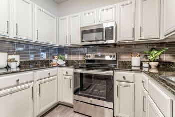 A kitchen with white cabinets and stainless steel appliances