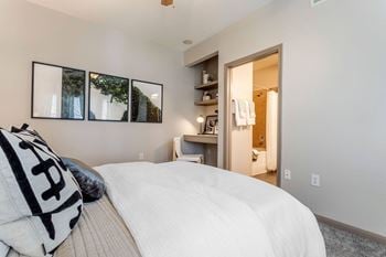 A master bedroom with a large bed and a bathroom