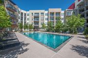 Dallas apartment for rent - an apartment pool with an apartment building in the background at South Side Flats, Dallas, TX