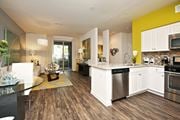 Woodland Hills apartment for rent - A modern kitchen with white cabinets and a wooden floor at The Kitt at Warner Center Apartments, Woodland Hills