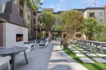 A patio with a fireplace and chairs.