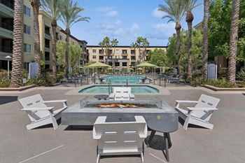 A pool surrounded by palm trees and chairs.