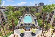Woodland Hills apartment for rent - A pool surrounded by palm trees and umbrellas at The Kitt at Warner Center Apartments, Woodland Hills 91303