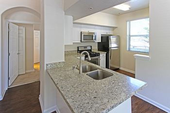 A kitchen with granite countertops and stainless steel appliances.