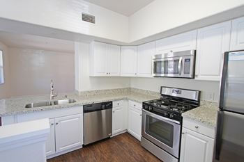 A kitchen with white cabinets and stainless steel appliances.
