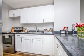 Waipahu apartment for rent - a white kitchen with marble counter tops and white cabinets