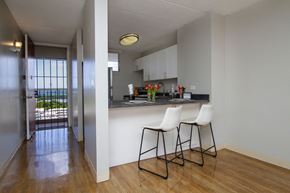 Waipahu apartment for rent - a view of a kitchen with two stools in front of a bar with chairs at Waikele Towers Apartments, Waipahu, HI