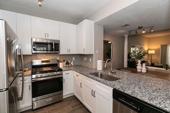 A kitchen with granite counter tops and stainless steel appliances