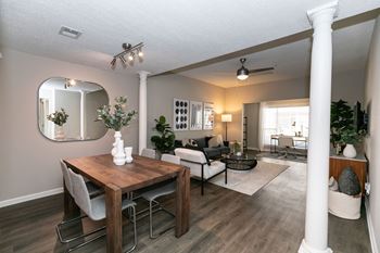 A dining room and living room with a table and chairs