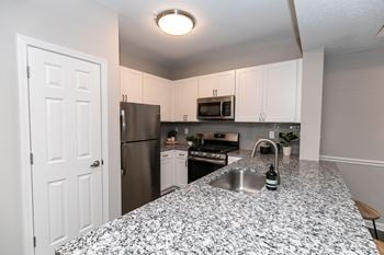 An expansive kitchen with granite counter tops and stainless steel appliances