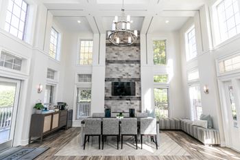 A living room with high ceilings and a large table and a fireplace