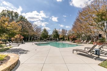  Pool and spa with trees and chairs around it